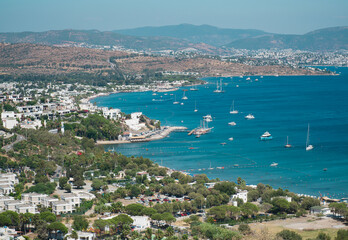 Fototapeta na wymiar Bodrum Town panoramic view at sunny day. landscape with marina, sailing boats, yachts in popular and touristic Bodrum city, Turkey
