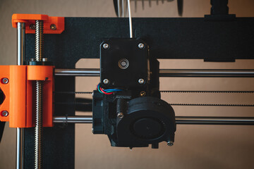 Technological hi-teg tool for making new things. A black and red 3D printer at work. The object is created by laying down continuous layers of material in additive processes.