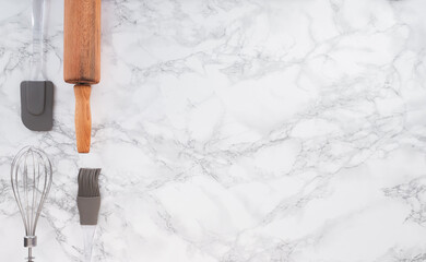 Cooking tools on a marble counter with space for lettering