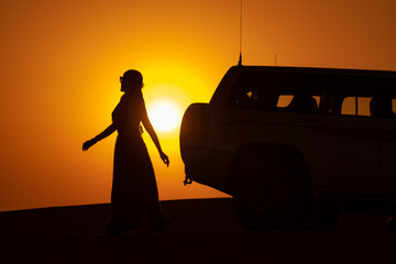 silhouette of a woman with a car