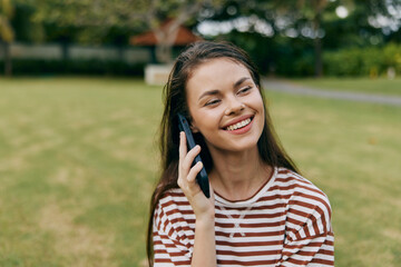 Naklejka premium phone woman grass smiling blogger tree park nature happy lifestyle palm student