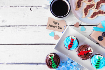 Fathers Day dessert side border. Top view on a white wood background. Gifts, greeting card, shirt cupcakes and mustache cookies.