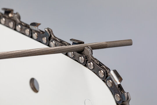 Sharpening chainsaw chain with file. Chain saw and lawn equipment maintenance, repair and service concept.