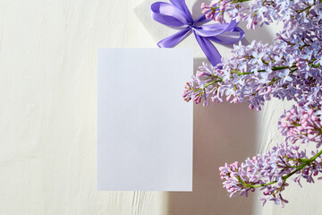 Mockup white greeting card with lilac branches on a white background