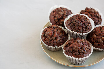 Homemade Dark Chocolate Muffins on a Plate, side view. Copy space.