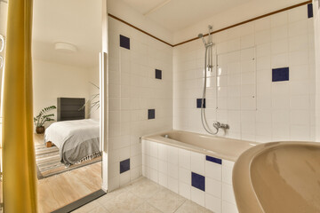 a bathroom with white tiles and blue trim around the tub, sink, and mirror in it's corner