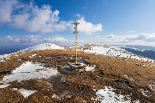 Ostredok, Velka Fatra, Slovakia, Europe - guidepost, signpost, signboard and board on the top of mountain and hill. Snow is melting in the spring. Sunny blue sky. Wide angle with distortion.