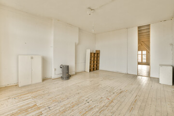 an empty room with white walls and wood flooring on one side, there is a heater in the corner