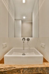 a white bathroom with marble counter top and mirror in the wall behind it is an open door that leads to a walk - in