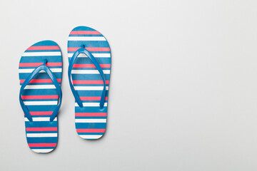Bright flip flops on color background, top view