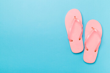Bright flip flops on color background, top view