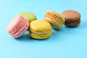 Colorful, sweet macarons, on a blue background, typical French and copy space.