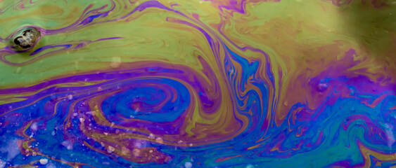 colored stains of gasoline oil on the water, iridescence