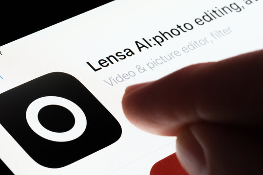Lensa AI app seen in App Store on the screen of ipad and blurred finger pointing at it. Selective focus. Stafford, United Kingdom, May 6, 2023