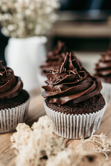 Delicious homemade chocolate cupcakes on nicely decorated  table. Sweet food concept.