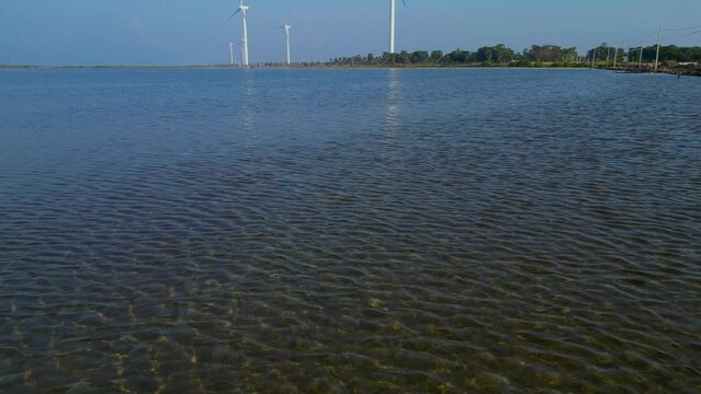 Aerial footage revealing a windmill by the sea