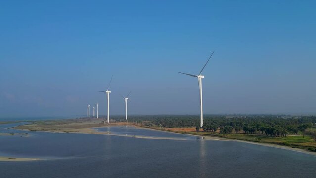 Aerial footage of a large windmill by the sea