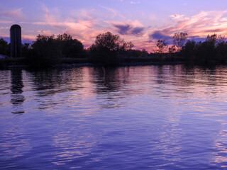 Naklejka premium purple sky on the water with silo in the background