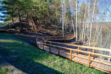 Wooden stairs with elevated walkway under construction, new construction, wooden structure, nature trail in forest.