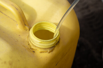 Red gas can with plastic tube in it. Syphoning gas from a car