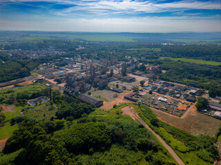 Fototapeta na wymiar Aerial image of chemical industry. Large structure of pipelines and warehouses with movement of cargo trucks. Industry surrounded by vast vegetation and trees. Located in Brazil, city of Paulínia.