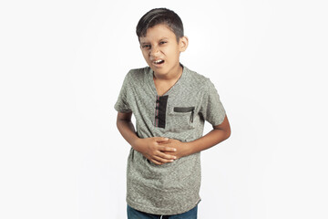 indian cute boy with belly pain holding tight in white background