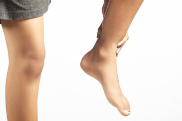 closeup shot of a women holding her injured ankle pain