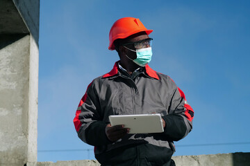 African american workman holds in hands white tablet computer
