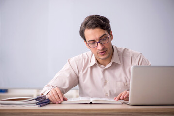 Young male teacher student sitting in the classroom