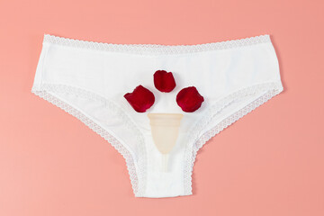 White briefs with menstrual cup and rose petals.