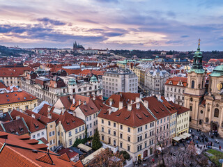 Naklejka na ściany i meble Aerial shot of Prague city historic buildings during colorful cloud sunset, Prague, Czech Republic