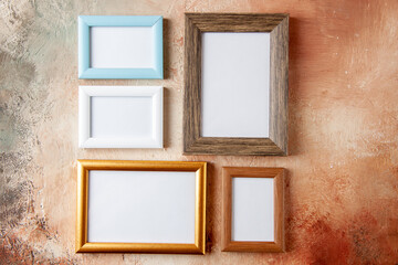 Front view of wooden photo frames in different sizes hung on side by side on mix color wall with free space