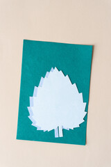 machine-cut lobed scrapbook paper leaves with serrated edges on green card and old beige art paper