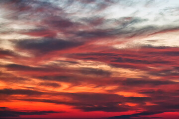 Background of the red, black and white cumulus clouds under the beautiful dramatic sunset sky. Clouds exert numerous influences on Earth's troposphere and climate.	