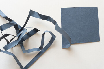 cut paper square with crushed ribbon element on beige 