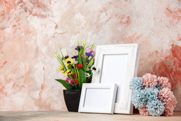 Top view of white small big empty wooden photo frames and beautiful flowers on mixed colors background