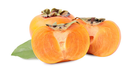 Whole and cut delicious ripe juicy persimmons with green leaf on white background