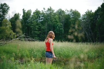 woman standing in the woods on a trail