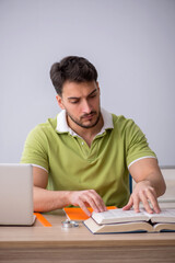 Young male student sitting in front of whiteboard
