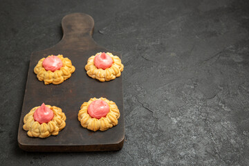 front view little sugar cookies with strawberry cream on the grey background biscuit sugar tea cookie sweet cake