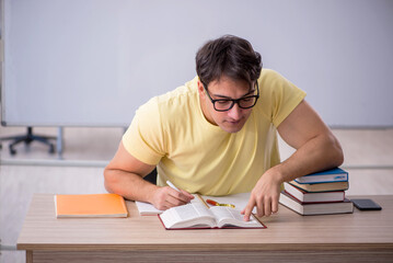 Young male student sitting in the classroom