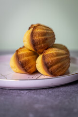 Madeleine cakes on a pink plate on a grey table - 600014533