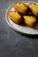 Madeleine cakes on a pink plate on a grey table - 600014537