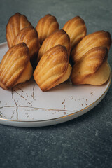 Madeleine cakes on a pink plate on a grey table - 600014552