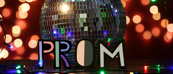 Word PROM and disco ball on dark background with blurred lights