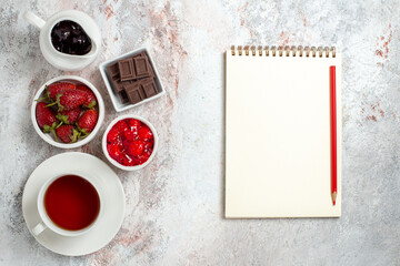 Obraz na płótnie Canvas top view cup of tea with jam and chocolate on a white background jam fruit tea drink