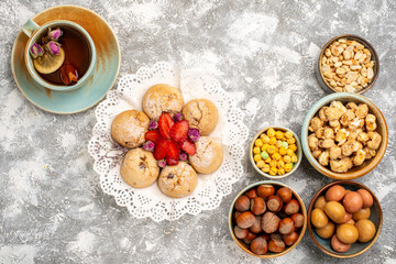top view cup of tea with nuts cookies and candies on white background nut tea candy snack