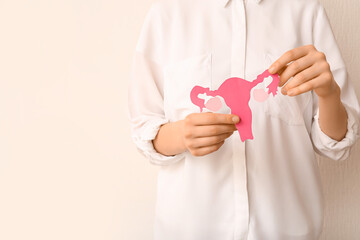 Woman with paper uterus on white background, closeup. Hormones concept