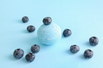 Bath bomb with blueberry on blue background