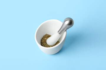 Mortar and pestle with spices on blue background